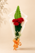 Ruby Romance Handcrafted Crochet Rose Bouquet – three deep crimson crochet roses with fern frond in white organza with orange satin bow