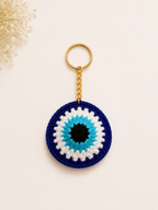 Guardian Gaze Handcrafted Crochet Evil Eye Keychain – navy blue circular medallion with turquoise and black evil eye design