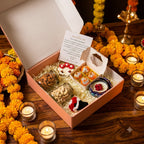 Diwali Gift Hamper Deluxe arranged in a festive box with scented candles, rose candle, dry-fruit jars, bouquet bag charm, and greeting card