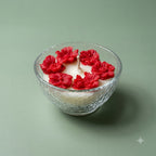 Red rose and leaf scented soy candle in a clear textured glass bowl