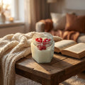 Scented red flower soy candle in a hexagonal glass jar styled in a warm lifestyle setting